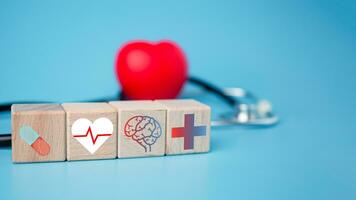 le concept de santé Assurance et médical bien-être. bloquer en bois et rouge cœur avec plus icône. santé Assurance et accès à santé se soucier. photo