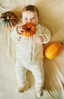 adorable bébé mensonge sur couverture, en jouant avec mini citrouille photo