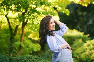 Extérieur portrait de content Jeune femme profiter environnement dans vert parc photo