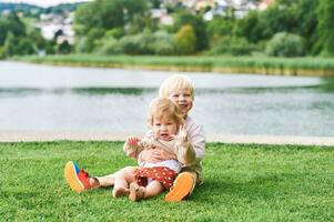 Extérieur portrait de adorable content les enfants en jouant ensemble suivant à Lac ou rivière, Fratrie l'amour photo