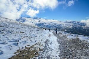 Latin famille en marchant par le neige dans le montagnes de sierra Nevada, avec hiver vêtements dans Grenade, Andalousie, photo