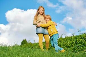 portrait de 2 marrant les enfants en jouant ensemble à l'extérieur photo