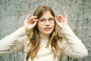 Extérieur portrait de Jeune content adolescent fille portant des lunettes photo