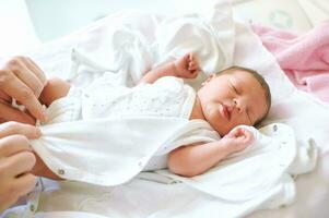 parent en changeant nouveau née bébé vêtements, premier heures de la vie photo