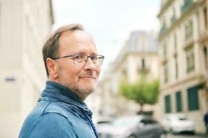 Extérieur portrait de milieu âge homme sur ville rue, portant lunettes photo