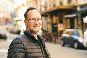 Extérieur portrait de milieu âge homme dans ville, portant bleu veste et lunettes photo