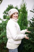 Extérieur portrait de content Jeune femme choisir Noël arbre à marché photo