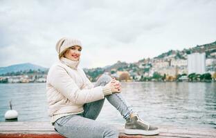 Extérieur portrait de content Jeune femme profiter agréable marcher par Lac Genève dans montreux ville, Suisse photo