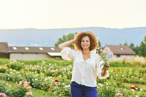 campagne mode de vie, Extérieur portrait de magnifique milieu âge 50 - 55 année vieux femme profiter agréable journée dans fleur ferme jardin photo