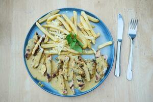 prêt à manger tranché poulet avec crème sauce avec français frites sur une assiette . photo