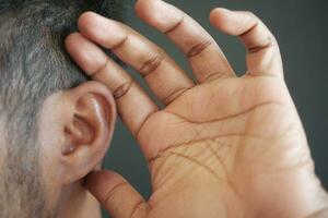 jeune homme ayant mal à l'oreille touchant son oreille douloureuse, photo