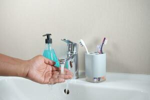 jeune homme se lavant les mains avec de l'eau chaude au savon photo