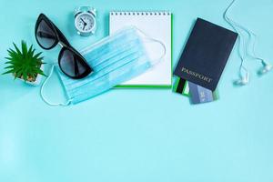 passeport et masque médical sur fond bleu. concept de voyage sûr pendant la pandémie de coronavirus. photo