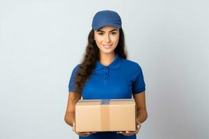 ai généré une souriant femme dans bleu chemise en portant une papier carton boîte. livraison femme remise papier carton boîte photo