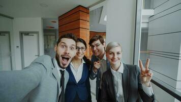 pov de content affaires équipe prise selfie portrait sur téléphone intelligent caméra et posant pour groupe photo pendant réunion dans moderne Bureau à l'intérieur