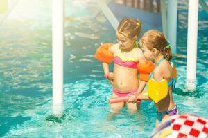 deux peu les filles en jouant dans le bassin photo