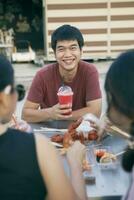 asiatique homme souriant avec bonheur souhait cool boisson bouteille dans main photo