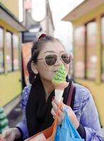 asiatique femme en mangeant vert thé crème glacée à Otaru rue Hokkaido Japon ,otaru est un de plus populaire en voyageant destination photo
