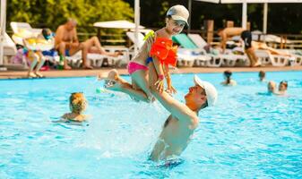 père en jouant avec le sien fille dans nager bassin photo