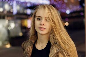 femme souriant dans le nuit contre soir lumières bokeh photo