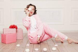 mignonne peu fille dans pyjama avec bonbons séance sur le sol photo