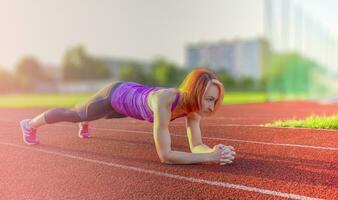 une beau, athlétique femme les trains sur le des sports champ. photo