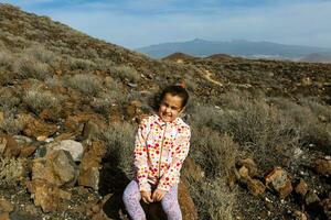 peu fille des stands près une cactus sur le île de Tenerife photo