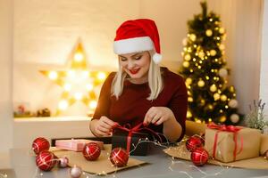 fermer sur table où femme fabrication Noël décorations. plus haut vue photo