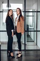 deux jolies filles d'affaires posant au bureau de travail photo
