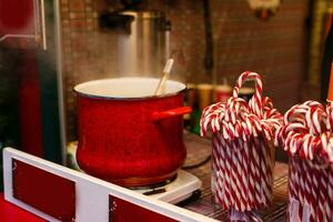 une géant pot plein de chaud Réchauffé rouge du vin avec épices sur le avènement Noël marché photo