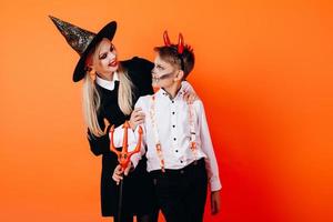 mère et soleil dans le maquillage de mascarade du diable se regardant. concept d'halloween photo