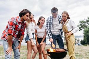 les amis du camp s'amusent et préparent des grillades photo