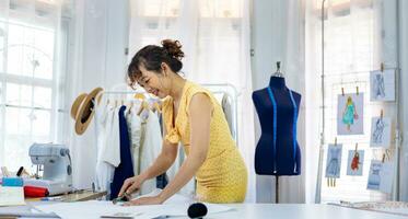 couturières est fabrication ajustement sur mousseline pour Nouveau Douane fabriqué robe tandis que travail dans artistique atelier studio pour mode conception et Vêtements affaires industrie concept photo