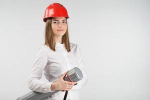 femme souriante se tient dans un casque orange tient le tube en gros plan photo