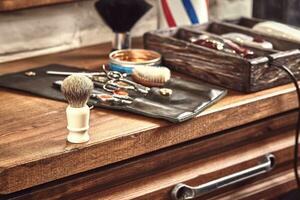 coiffeur outils sur en bois Contexte. Haut vue sur en bois table avec ciseaux, peigne, brosses à cheveux et pinces à cheveux, tondeuse. photo