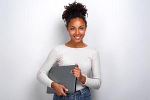 jeune fille tenant un ordinateur portable en se tenant debout dans le studio photo