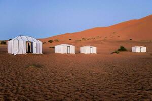 le tentes sont dans le désert avec le sable dunes photo