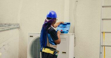 qualifié africain américain dépanneur départ routine entretien sur externe HVAC système, en train de préparer boîte à outils. ingénieur avoir outils prêt pour vérification défectueux air Conditionneur interne les pièces photo