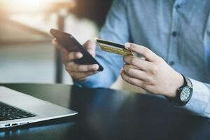 en ligne achats et l'Internet Paiements, asiatique homme sont en utilisant leur mobile Téléphone (s et crédit cartes à magasin en ligne ou conduite courses dans le numérique monde. photo