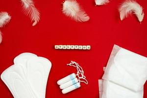 ovulation, serviettes hygiéniques et tampons sur fond rouge, vue de dessus. photo