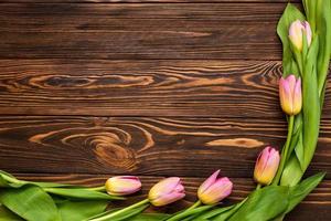 journée de la femme. bouquet de tulipes roses sur fond de planches de bois, espace copie, vue de dessus photo