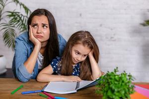 mère devenir frustré avec fille tandis que Faire devoirs séance à le table à Accueil dans apprentissage des difficultés devoirs. photo