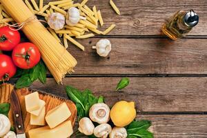 Ingrédients pour spaghetti avec basilic, tomates, fromage sur en bois arrière-plan, Haut voir, endroit pour texte photo