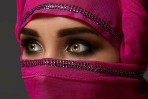 fermer coup de une Jeune charmant femme portant le rose hijab décoré avec paillettes. arabe style. photo
