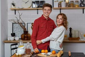 content Jeune charmant couple sur cuisine étreindre chaque autre. elles ou ils prendre plaisir dépenses temps togehter photo