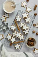 Noël traditionnel allemand biscuits, cannelle étoiles avec noisettes sur une lumière béton Contexte. Haut voir. photo