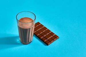 verre de Chocolat Lait avec Chocolat bar sur bleu Contexte avec espace pour texte ou conception photo