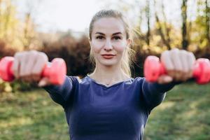 belle jeune femme travaillant avec des haltères, dans le cadre de son mode de vie. photo