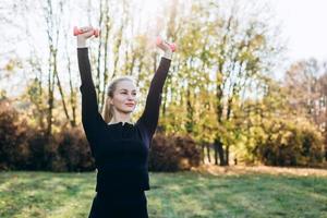 une jeune femme fait du sport en plein air. fille aux cheveux blonds s'entraîne dans le parc sur la nature. photo