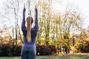 femme dans la forêt vue arrière activité de plein air jeune femme séduisante faisant de l'exercice travaillant à l'extérieur. vue arrière photo